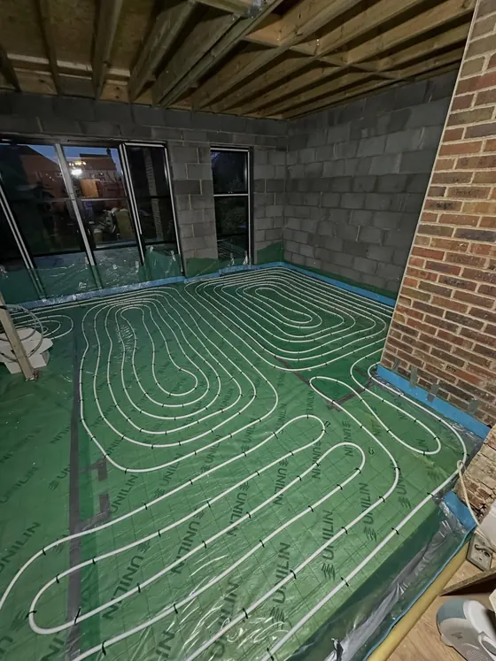 Underfloor heating pipes laid across a new floor