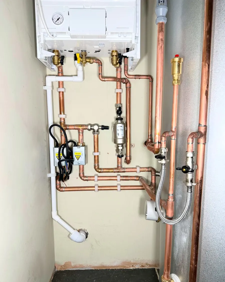 Neat parallel copper pipework under a boiler, fitted by Addisons