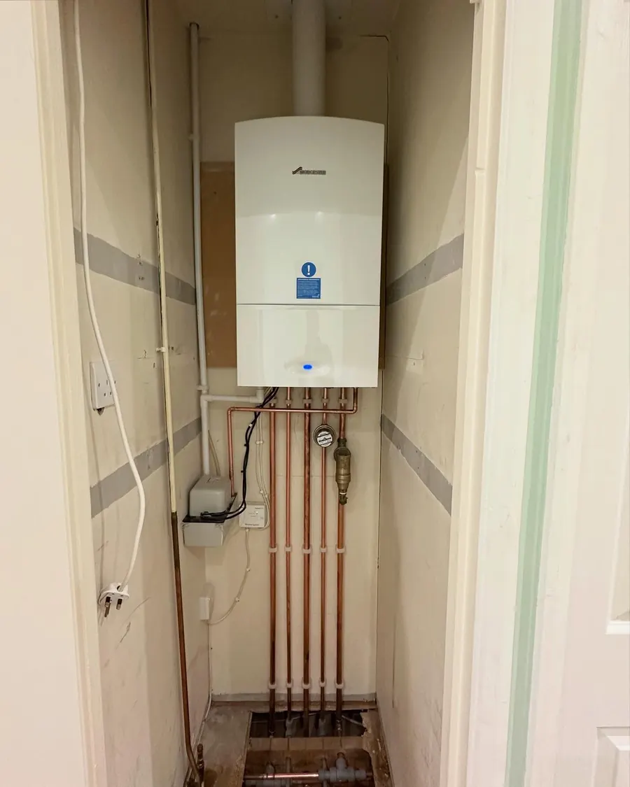 Straight vertical copper pipework below a combi boiler, fitted by Addisons