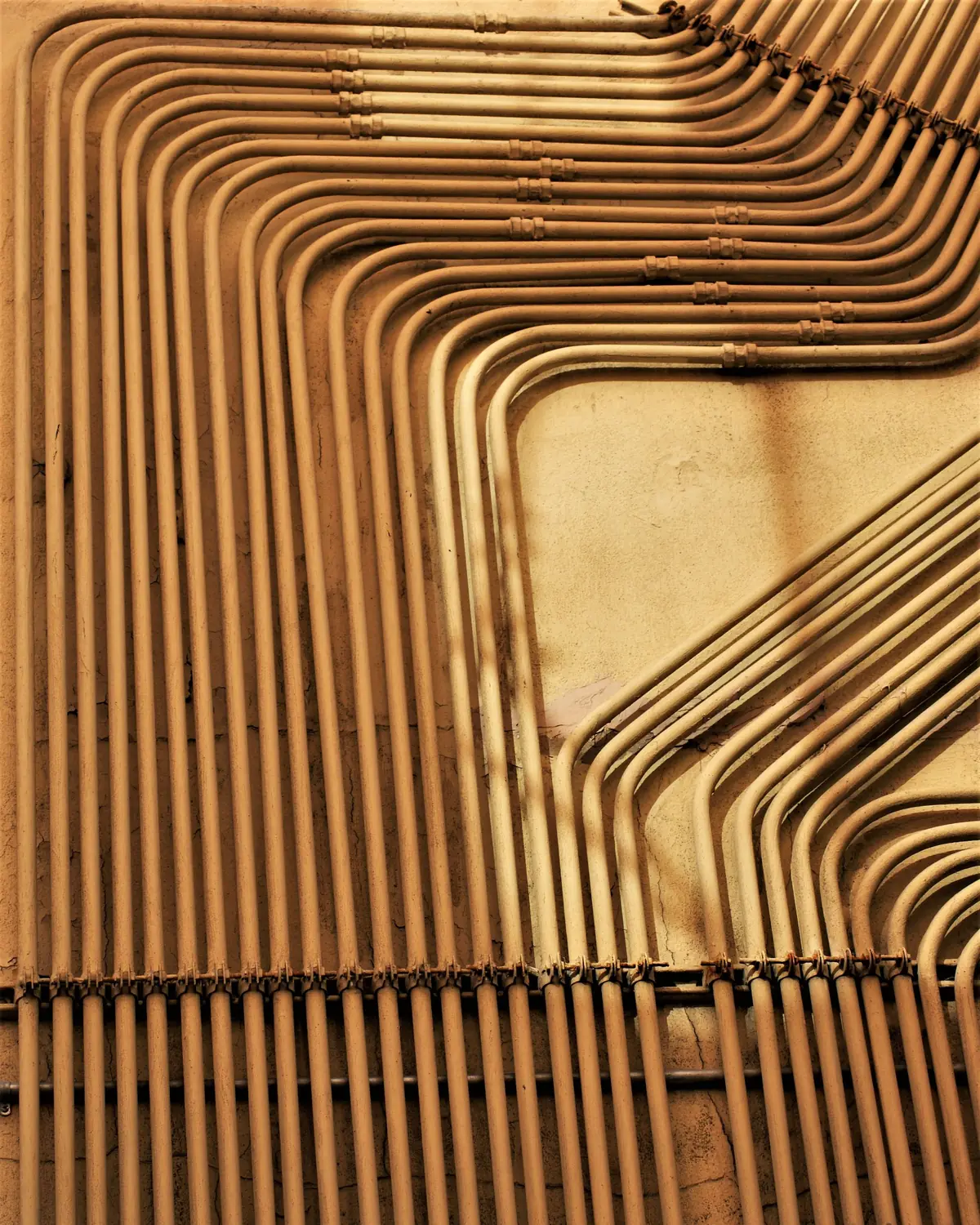 Rows of copper pipe bent in neat, evenly spaced parallel runs